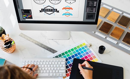 Diseño gráfico con tableta digital, muestras de color y un ordenador.
